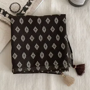 Détail de foulard carré vintage à motif losanges, élégant accessoire de mode et ruban de sac.