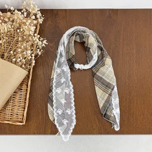 Detail shot of vintage plaid silk scarf with delicate white lace trim and pearl button accent.