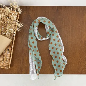Green polka dot chiffon scarf with white lace trim and pearl ring accessory for women.