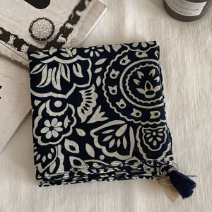 Vue détaillée d'un carré de soie ou foulard vintage bleu marine à motif avec franges.