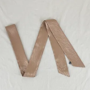 Detail view of the elegant wavy thin long streamer, perfect as a chic hair tie or bag accessory.