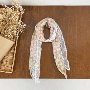 Close-up detail of the polka dot lace spliced silk scarf with a pearl buckle, artistic style.