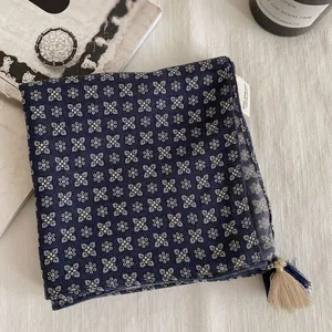 Vue détaillée du foulard carré à motif floral vintage bleu foncé avec gland et étiquette.