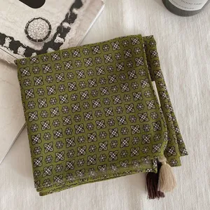 Détail de foulard carré floral vert rétro vintage avec bordure à franges élégante et tissu.
