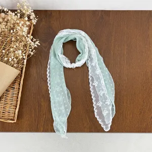 Chic light green lace patchwork silk scarf with delicate white lace trim and pearl brooch detail.