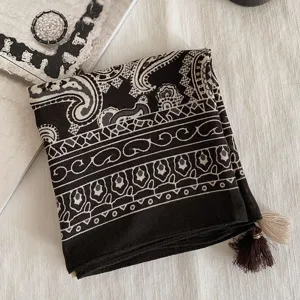 Gros plan detaille du foulard carre avec motif cachemire vintage et de jolis pompons.