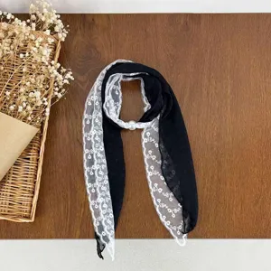 Detailed view of the elegant black and white lace spliced scarf with pearl buckle accessory.