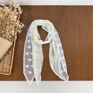 Detailed shot of green plaid lace scarf with pearl buckle, vintage style neckerchief accessory.