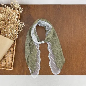 Close-up detail of Korean polka dot lace spliced pearl silk scarf fashion accessory.