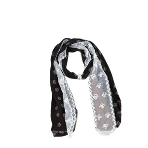 Elegant women's dark paisley silk scarf with white lace trim and pearl buckle accessory.