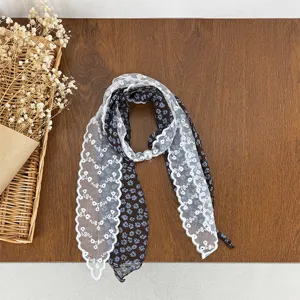 Detail shot of the stylish floral print neckerchief featuring white lace trim and pearl clasp.