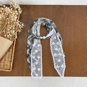Women's elegant silk scarf with delicate white lace trim and pearl buckle, chic spring ribbon accessory.