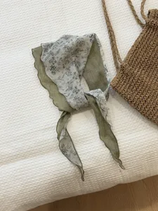 Detailed close-up shot of the vintage floral triangular headscarf and tie neckerchief in green.