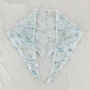 Vue détaillée du foulard triangulaire à motif floral avec imprimé nœud et tissu léger.