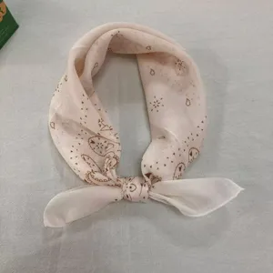 Detailed view of vintage cotton linen small square scarf with elegant brown paisley print.