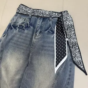 Vintage blue denim jeans featuring a chic black and white paisley and polka dot ribbon belt.