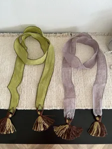 Close-up details of the vintage forest-style long ribbon scarf with delicate tassel decor.