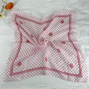 Detail shot of the pink gingham floral square scarf, showcasing delicate rose print.