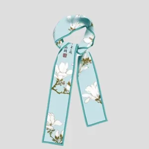 Light blue skinny silk scarf featuring white magnolia print and delicate calligraphy details.