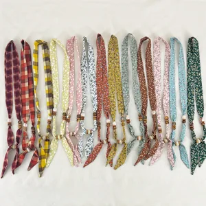 Detailed view of vintage floral and plaid fabric scarf necklaces with wooden bead accents.