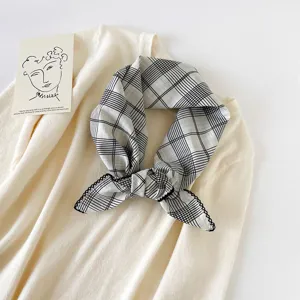 Detail view of black and white plaid small square scarf, lightweight fabric, versatile neckwear.