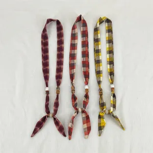 Detailed closeup view of retro plaid fabric necklaces featuring wooden beads and stylish ribbon ties.