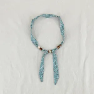 Vintage floral fabric scarf necklace with wooden beads, stylish retro neckerchief accessory.