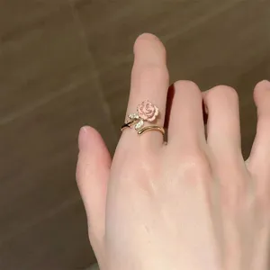 Pink enameled rose adjustable ring, gold-plated open band with sparkling cubic zirconia leaves.