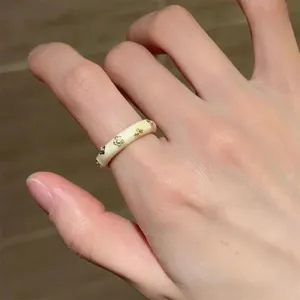 Chic cream enamel gold flower ring, elegant minimalist stackable fashion jewelry for women.