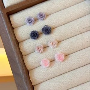 Detailed shot of exquisite mini rose flower stud earrings in multiple elegant colors.