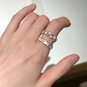 Detailed close-up view of delicate alloy rings featuring floral designs and sparkly crystal stones.