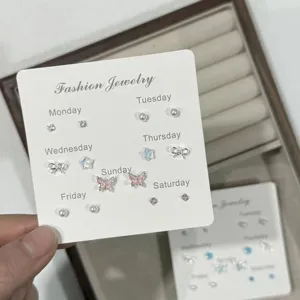 Close-up detail of the cute weekly butterfly and bow stud earrings set on white display card.
