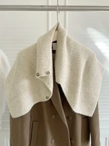 Strickschal Detail mit hohem Kragen, strukturierter Wolle und vorderem Knopfverschluss.