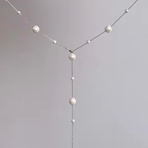 Collier de perles élégant en Y avec chaîne argentée fine, design minimaliste, détail de bijoux.