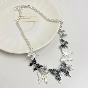 Gros plan du collier papillon style doux à goutte d'huile, au design de niche unique.