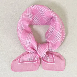 Detailopname van roze geruite vierkante sjaal, elegant accessoire voor nek en haar.