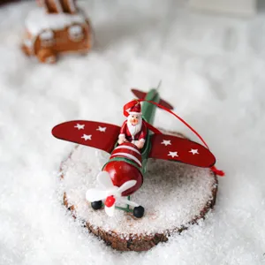 Gros plan d'un charmant pendentif de sapin de Noël en métal représentant le Père Noël en avion.