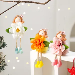 Detail view of cute Easter angel hanging ornaments holding artificial flowers for spring decor.