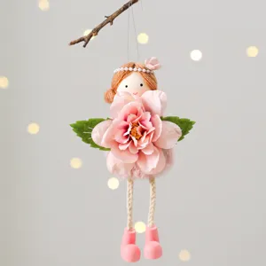Close-up detail of hanging angel doll decor holding pink flower with soft bokeh background.