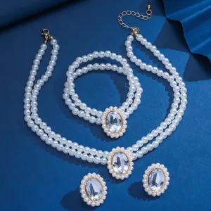 Set di gioielli con collana bracciale e orefini di perle con grande cristallo.