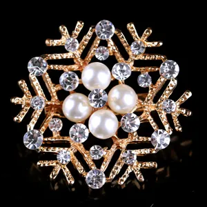 Exquisite snowflake brooch detail featuring gold-toned metal, sparkling crystals and pearls.