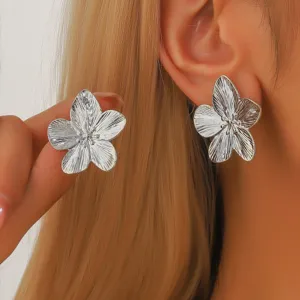 Primo piano dettagliato di eleganti orecchini a forma di fiore in metallo argentato.