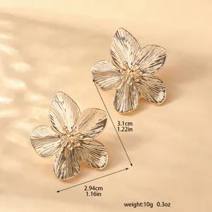 Orecchini a fiore metallici oro stile vintage elegante gioiello moda accessorio dettaglio.