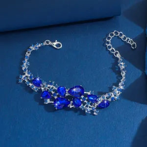Meraviglioso bracciale da sposa in lega argentata con strass blu a goccia, dettaglio in primo piano.