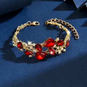 Bracciale in lega dorata con cristalli rossi a goccia e strass trasparenti brillanti.