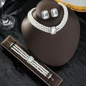 Elegante set di gioielli in tre pezzi con collana di perle, bracciale e orecchini di cristallo.