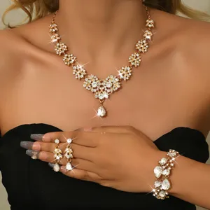 Primo piano del set di gioielli da sposa scintillante con collana e orecchini dorati.