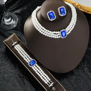 Primo piano dettagliato del set di gioielli di perle finte multistrato con cristallo blu e orecchini.