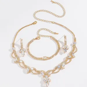 Vista di dettaglio di collana, bracciale e orecchini da sposa in strass con finitura dorata.