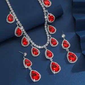 Primo piano dettagliato di una collana in cristallo rosso con gocce e orecchini abbinati.